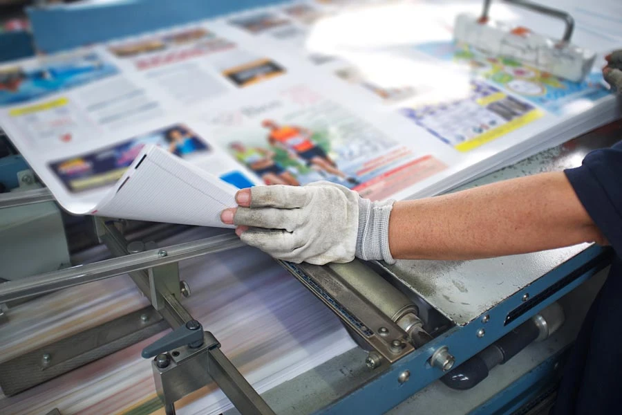 Échange entre une professionnelle et un partenaire dans un atelier d'imprimerie.